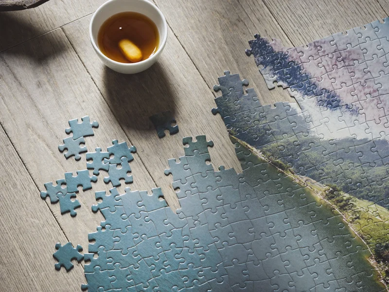 Fertig gelegtes 1000-Teile-Puzzle mit Bergsee-Motiv auf hellem Eichentisch