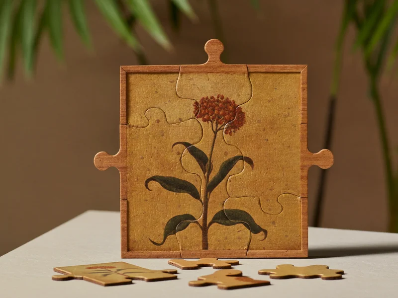 Teilweise gelegtes Holzpuzzle mit botanischem Motiv und losen Teilen im Vordergrund
